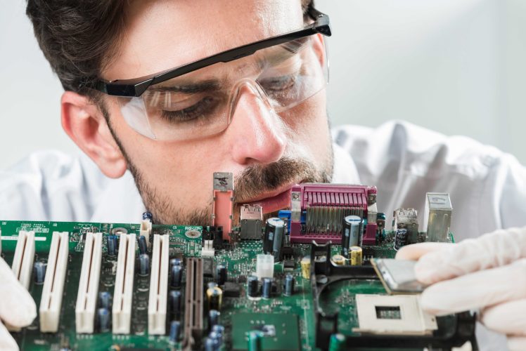 male-technician-inserting-chip-computer-motherboard